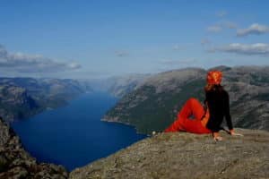 Traversée Norvège : Randonneuse face au vide des fjords en Norvège