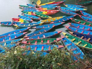 Voyage au Népal en famille à Pocara : de nombreuses barques colorées sur la rivière Akaoka