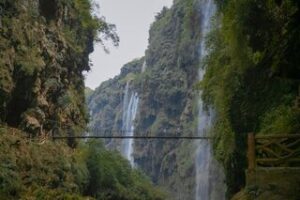 Voyage en Chine à Guizhou : des cascades d'eaux avec un pont reliant les deux montagnes Akaoka