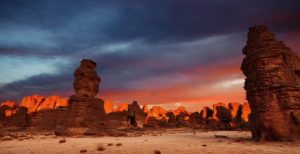 Randonnée chamelière en Algérie sous un coucher de soleil dans le désert Tassili Akaoka