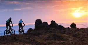 Deux personnes qui font du VTT sur la montagne avec un magnifique coucher de soleil en Roumanie