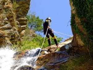 Kayak Oman : une femme faisant du canyoning en descendant une cascade