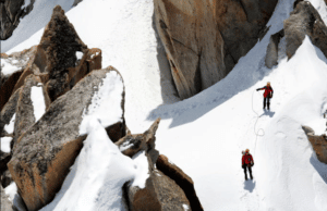 Alpinisme du Mont Blanc : Randonneur sur le chemin plein de neige vers le sommet de la montagne