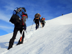 Randonneur sur le chemin plein de neige vers le sommet de la montagne, maison de la Montagne