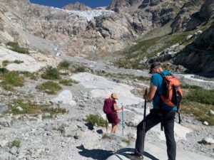 Randonnée Couple faisant de la marche nordique dans la vallée des écrins accompagner et ils descendent une colline.